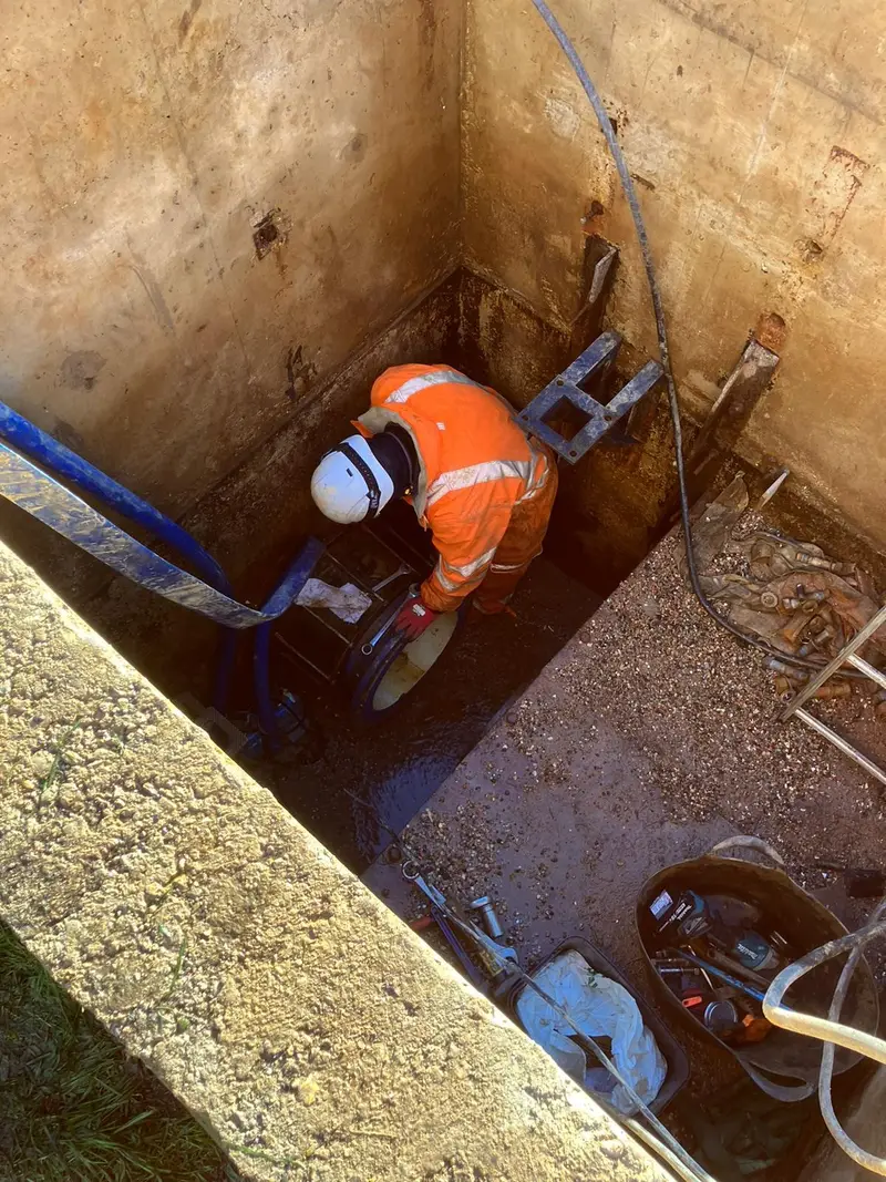 Engineer working on pipework at the bottom of a shored excavation
